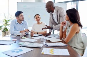 Four dedicated team members collaborating around a table, actively discussing strategies for team development and growth.